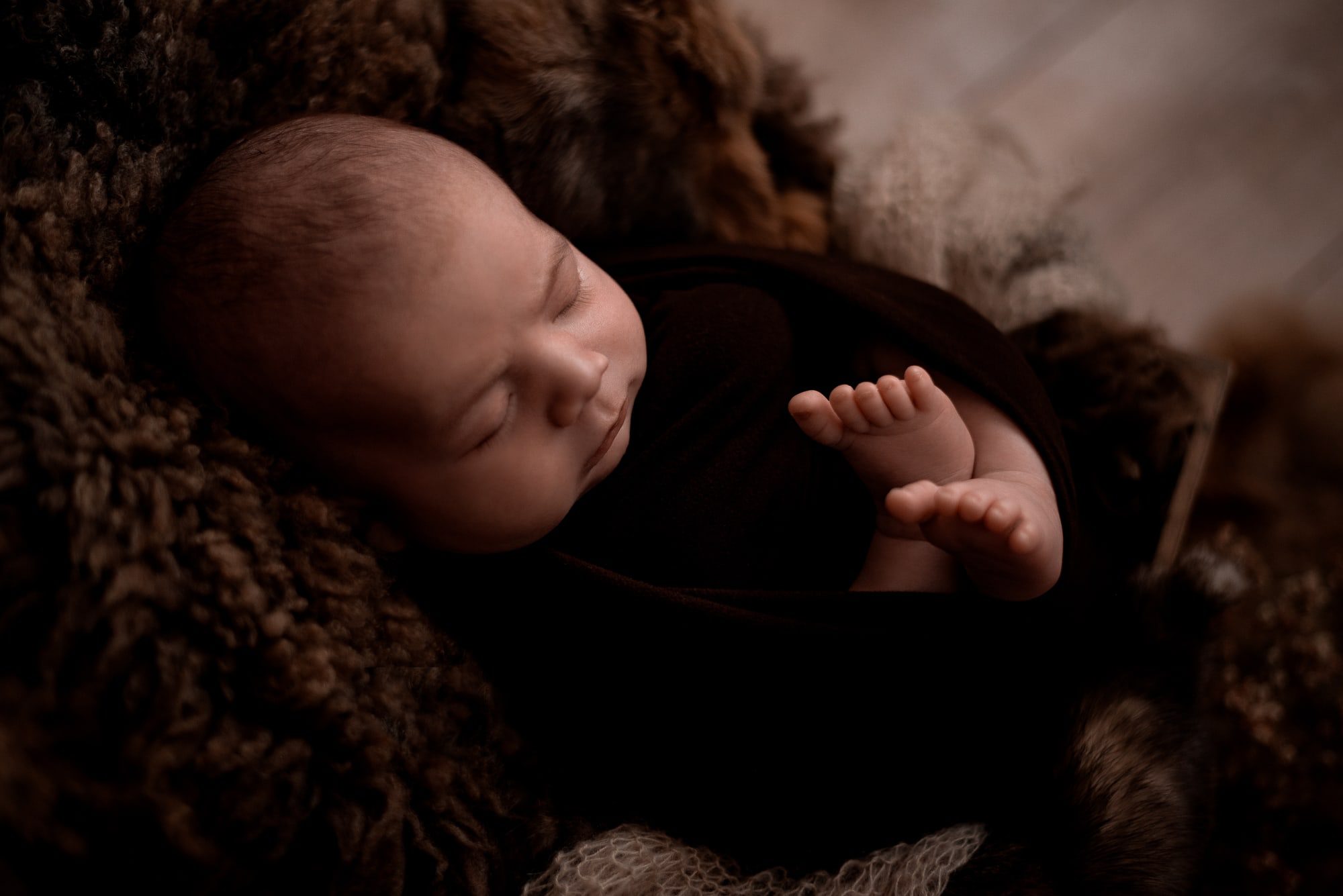 Bébé emmailloté sur peau mouton